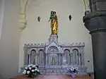 Le tabernacle est surmonté d'une statue de la Vierge à l'Enfant