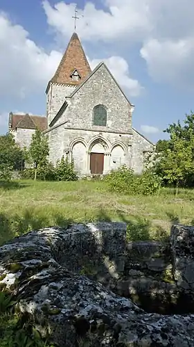 Vue du portail ouest de l'église et d'un puits ou baptistère.