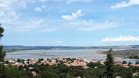 Étang de Lapalme depuis les hauteurs de la Franqui. Au loin, sous les éoliennes: la ville de La Palme.