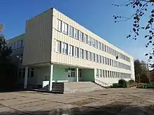 Photographie en contre-plongée d'un bâtiment blanc de style moderne en préfabriqué avec deux étages.