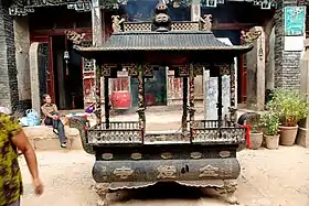 Un petit meuble carré en plein air, surmonté d'un petit toit.