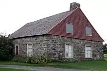 une maison en pierre avec un toit en bardeau de bois