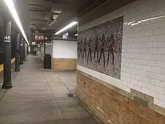 espace étroit entre les colonnes et le mur, inscription Exit avec flêche vers la droite