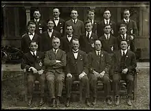 photo en noir et blanc d'hommes en costume alignés sur trois rangs