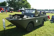 Photographie d'une jeep verte, amphibie. La forme générale est celle d'un bateau avec un volant et poste de conduite proche de celui d'une voiture.