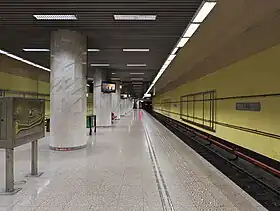 Photo floue du quai central, avec une rangée de colonnes, et une voie