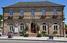 Vue d'un bâtiment à un étage portant l'inscription « mairie » à son fronton.