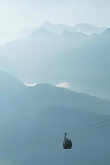 Une cabine toute petite dans le vertige d'une brume bleutée, simplement soutenue par quelques câbles.