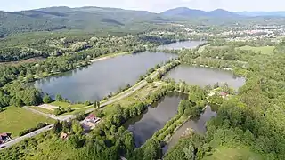 Les ballastières de Champagney surplombées par les Vosges dont la Planche des Belles Filles.