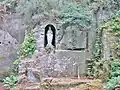 Locuon ː la "grotte de Lourdes" et les traces de la découpe abandonnée d'un bloc sur la paroi rocheuse.