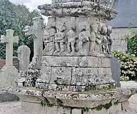 Locuon ː la base du calvaire, illustrant la Passion du Christ, du calvaire situé dans l'enclos paroissial de l'église Saint-Yon.