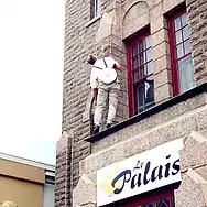 Performeur allant accrocher l'horloge.