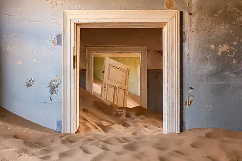 Une maison envahie par le sable.
