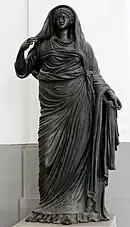 femme debout en robe et drapé, tête couverte