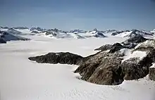 Un paysage neigeux avec des montagnes rocheuses.