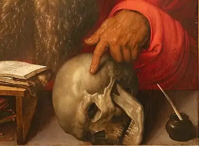 L'index pointant le crâne.