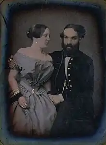 le compositeur, de face, tient de la main gauche la main droite de la jeune femme placée à sa droite et qui le regarde, tandis qu'il l'enlace du bras droit