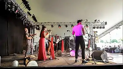 Mark Glanville (en) frappe avec une baguette une bouteille en verre au WOMAD avec le groupe Amaraterra