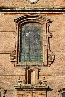 La verrière ornée de volutes baroques.