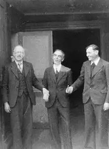 Photo noir et blanc de trois hommes se tenant le bras