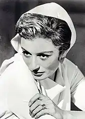 Portrait en plongée de trois quarts d'une femme aux traits fins, l'élégante coiffure protégée par un foulard.