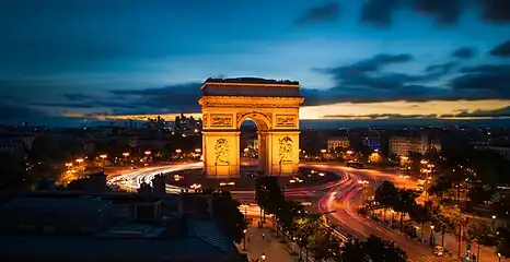 Vue de l'arc depuis une terrasse le surplombant, de nuit.