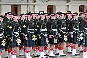 Photographie de militaires en formations portant des kilts et tenant des fusils