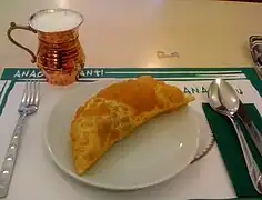 Çibörek : chausson de pâte phyllo et viande hachée, avec un pot d'ayran.