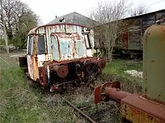 Locotracteur trapu peint en blanc et fortement dégradé et rouillé.