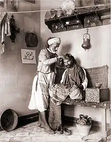 Un barbier exerçant son métier à Algérie, vers 1892.