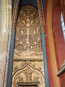 En partant du bas vers le haut, Dieu le Père tenant l'Univers est accompagné de deux anges agenouillés. Ces trois personnages sont surmontés par Adam et Ève se couvrant les parties intimes. Au-dessus, Jessé est représenté comme un vieil homme barbu et endormi. De son corps sort un arbre dont les branches portent les statues et les noms des rois légendaires de Juda. Sur le tronc, sont représentés David, deuxième roi de Juda, et Jechonias, avant-dernier roi de Juda. Enfin, en haut de l'arbre, Marie est surmontée de son fils Jésus sur la croix