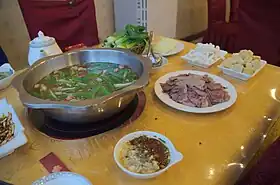 Fondue au chien de la minorité Buyei du :bourg de Huajiang (zh) à Pékin.