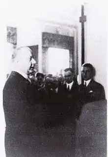 photographie en noir et blanc d'un groupe de personnes dans une pièce.
