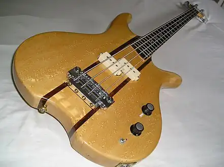 Guitare basse électrique avec dessus en érable moucheté.