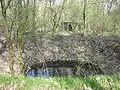 Bunker souterrain allemand situé à côté de l'ancien camp. Cratère de bombe au premier plan