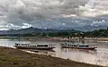 Bateaux sur le Mékong avec des nuages sombres et du ciel bleu en fin d'après-midi à Luang Prabang. Septembre 2023.
