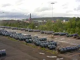 photo d'un parc à bobines. En arrière plan, l'usine