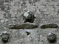 Têtes sculptées ornant la façade ouest de l'église.