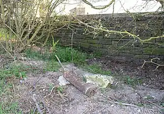 Obus non explosé derrière le mur du cimetière (photo prise le 21/03/2022).