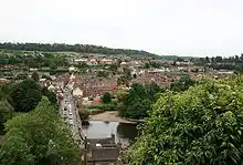 Vue de loin d'une petite ville nichée au milieu d'une forêt.