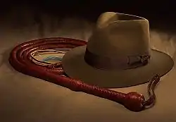 Photographie du chapeau et du fouet enroulé exposés dans un musée.