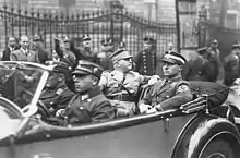 Photogphie en noir et blanc de Rhöm, assis sur le siège arrière d'une voiture, à côté de Karl Ernst