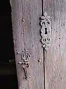 Détail de la serrure en fer forgé portant le monogramme IHS abréviation de Jésus en grec.