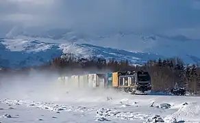 Un train de l'opérateur CargoNet tiré par une Stadler Euro Dual entre Oteråga stasjon (no) et la gare de Valnesfjord sur la ligne du Nordland. Mars 2023.