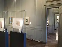 Vue de dessins sous verre et de l'enfilade des pièces.