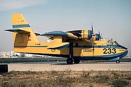 vue de profil d'un canadair jaune et bleu au sol.