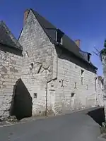 Photographie en couleurs d'un bâtiment au haut pignon pointu.