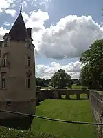 Tour droite du château et vue des douves vides et d'une partie du golf