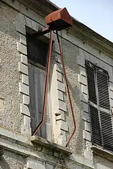 Vue d'un côté d'un bâtiment avec une fenêtre et une installation en fer rouillé