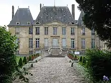 photo : un château au fond d'une allée pavée
